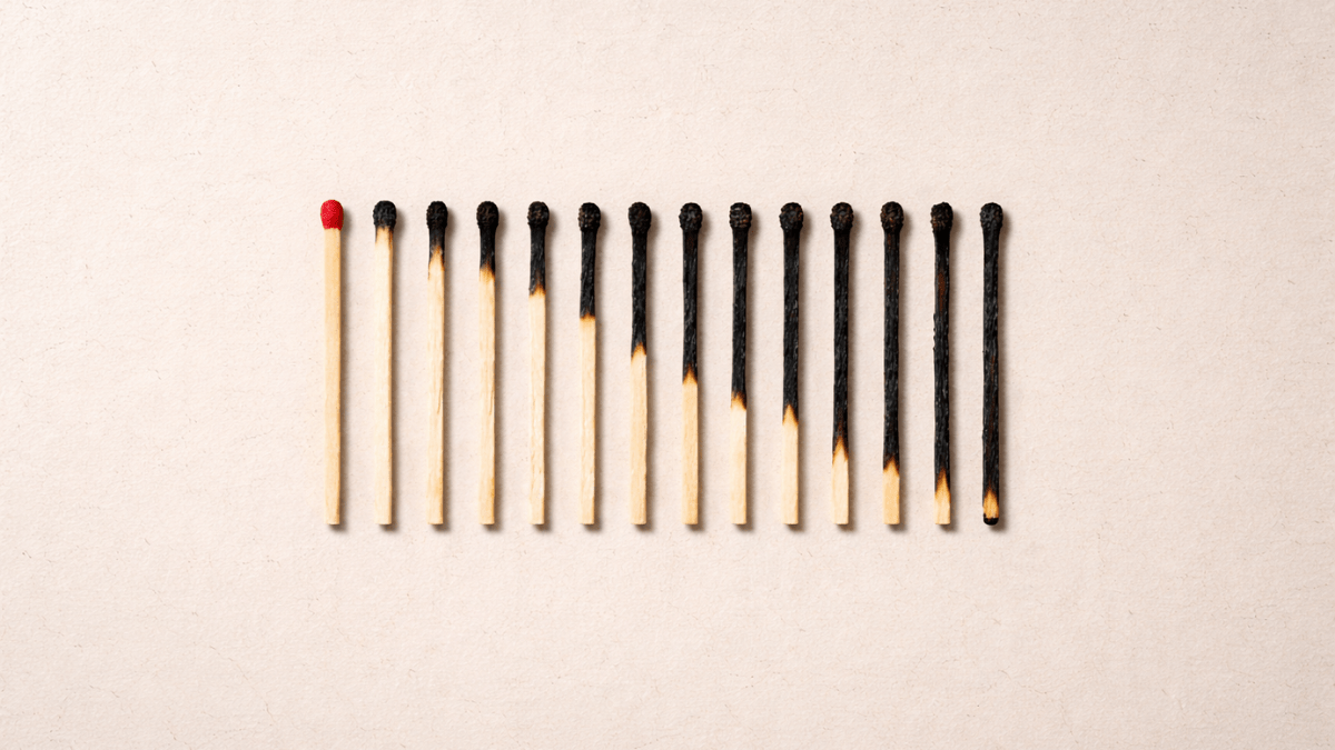 A row of wooden matches gradually burned from left to right on a neutral beige background